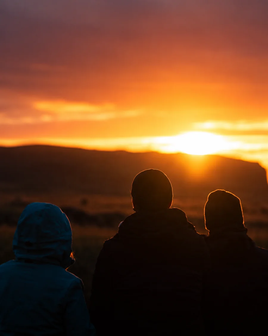 Three hikers seen in silhouette at sunset